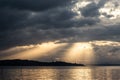 Sunrays at near sunset, with dark clouds in the background, above Trasimeno lake Umbria, Italy Royalty Free Stock Photo