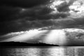 Sunrays at near sunset, with dark clouds in the background, above Trasimeno lake Umbria, Italy Royalty Free Stock Photo