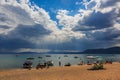 Sunrays seen above the water over Lake Tahoe in California, USA, tourists relaxing on the beach and boats in the water Royalty Free Stock Photo