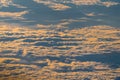 Sunrise above fluffy clouds from an airplane window with sunlight. Abstract nature texture background. Royalty Free Stock Photo