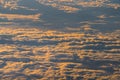 Sunrise above fluffy clouds from an airplane window with sunlight. Abstract nature texture background. Royalty Free Stock Photo