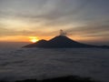 Sunrise above Lake Batur Covered with Clouds and Mount Agung Erupting Smoke - Seen from Top of Mount Batur in Bali, Indonesia. Royalty Free Stock Photo