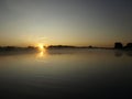 Sunrise above a river on foggy summer morning, the sky reflections in the water,  misty reflection in steaming water, Royalty Free Stock Photo