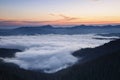 Sunrise. Amazing landscape with high mountains, fog and sky. The early morning mist. Majestic spring day. Fog with beautiful light