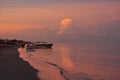 Sunrise, beach and a fisherman`s boat