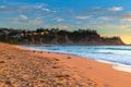 Sunrise at the Beach with light cloud and headland with houses