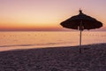 Sunrise on the beach with parasol overlooking the sea Royalty Free Stock Photo