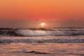 Sunrise beach shot with sun rays shining on waves Royalty Free Stock Photo