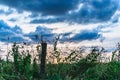 Sunrise behind a metal barbed wire fence over natural meadows with green grass Royalty Free Stock Photo