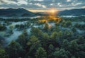 Sunrise Breaks Over A Mist-Enshrouded Forest Nestled Between Layered Mountain Ridges Royalty Free Stock Photo