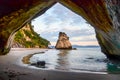 Sunrise at Cathedral Cove with blue sky with white clouds above and refelction in the sea, golden hour Royalty Free Stock Photo