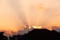 Sunrise cloud and beam of sun in the morning with silhouette of roof and treetops