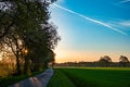 Sunrise on Country Road with Contrail in Sky Royalty Free Stock Photo
