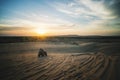Sunrise in desert. Scene with two ATV bikers. Tourists ride on an off-road ATV through the sand dunes of the Vietnamese desert. Royalty Free Stock Photo