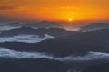 Sunrise on distant mountains with fog