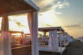 Sunrise in the early morning on the beach with closeup of white curtains on aligned romantic wooden sunshades house parasol beach Royalty Free Stock Photo