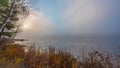 Sunrise through early morning fog on a lake near Ottawa, Ontario. Royalty Free Stock Photo