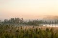 Sunrise in evergreen forest with bog, haze over water and land, northern Karelia, Russia Royalty Free Stock Photo