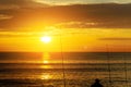 During a sunrise fisherman catches fish one ocean