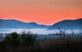 Sunrise with fog, mountains and town in the background Royalty Free Stock Photo