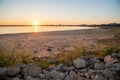 Sunrise at Grapevine Lake in Texas, USA with first appearance of light in the sky at dawn, rocky bank and sandy shoreline, fishing