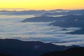 Fog lies over the mountains and yellow highlights the sky in the Smokies. Royalty Free Stock Photo