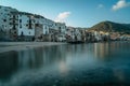 Sunrise in harbor of Cefalu, Sicily, Italy, old town panoramic view with colorful waterfront houses, sea and La Rocca cliff. Royalty Free Stock Photo