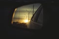 Sunrise on highway road in left side view mirror driver. Focus on reflection in smaller mirror. Royalty Free Stock Photo