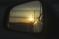 Sunrise on highway road in left side view mirror driver. Focus on reflection in smaller mirror. Royalty Free Stock Photo