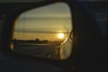 Sunrise on highway road in left side view mirror driver. Focus on reflection in smaller mirror. Royalty Free Stock Photo