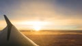 Sunrise from inside an airplane where you can see the wing and cloud background Royalty Free Stock Photo