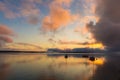 Sunrise on the lake with boats, reflection of sun in water, with fog and clouds on summer morning Royalty Free Stock Photo