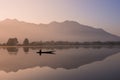 Sunrise at lake and mirror shadow symmetry with silhouette fisherman on boat Royalty Free Stock Photo