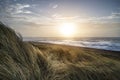 Beautiful sunrise landscape image of sand dunes system over beach with wooden boardwalk Royalty Free Stock Photo