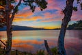 Sunrise landscape. Lake surrounded by mountains and hills. Colorful sky. Amazing water reflection. Nature background. Foreground Royalty Free Stock Photo