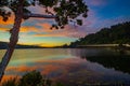 Sunrise landscape. Lake surrounded by mountains and hills. Colorful sky. Amazing water reflection. Nature background. Foreground Royalty Free Stock Photo