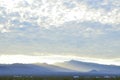 Sunrise light rims edge of massive cloud bank over Spring Mountains and the Mount Charleston peak with misty valleys Royalty Free Stock Photo