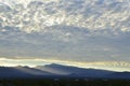 Sunrise light rims edge of massive cloud bank over Spring Mountains and the Mount Charleston peak with misty valleys Royalty Free Stock Photo