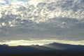 Sunrise light rims edge of massive cloud bank over Spring Mountains and the Mount Charleston peak with misty valleys Royalty Free Stock Photo