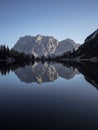 Sunrise mirror reflection of Zugspitze mountain massif in clear calm alpine lake Seebensee in Ehrwald Tyrol Austria alps