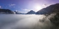 Sunrise morning clouds between trees of tirol mountains above lake plansee Royalty Free Stock Photo