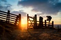 Sunrise in mountain hills hiker climber climbing over wooden fence style silhouette with open gate sun rising over countryside. Royalty Free Stock Photo
