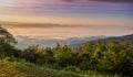 Sunrise at mountain terrain in a sea of mist, on cloudy sky. Beautiful panoramic view of highland.