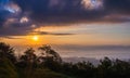 Sunrise at mountain terrain in a sea of mist, on cloudy sky. Beautiful panoramic view of highland.