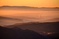 Sunrise in mountains, shape of hills in morning mist, white edit space Royalty Free Stock Photo