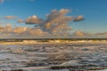 Sunrise North Sea beach of the Netherlands with yellow surf and wave crests