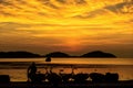 Sunrise with orange sky and silhouette of man sit on rock and pa Royalty Free Stock Photo