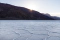 Sunrise over Badwater Basin, Death Valley, California. Sunburst over mountains in the distance; foreground covered with white salt Royalty Free Stock Photo