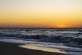 Sunrise over the Black sea, waves on the sandy beach.