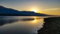 Sunrise over a dark lake with mountain range Royalty Free Stock Photo